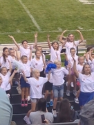 Cheerleaders-in-training assist cheerleaders with keeping the crowd and parents' spirit high.